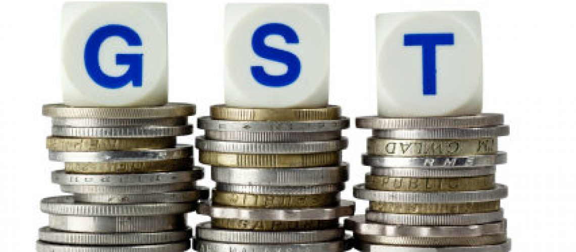 Stacks of coins with the letters GST isolated on white background