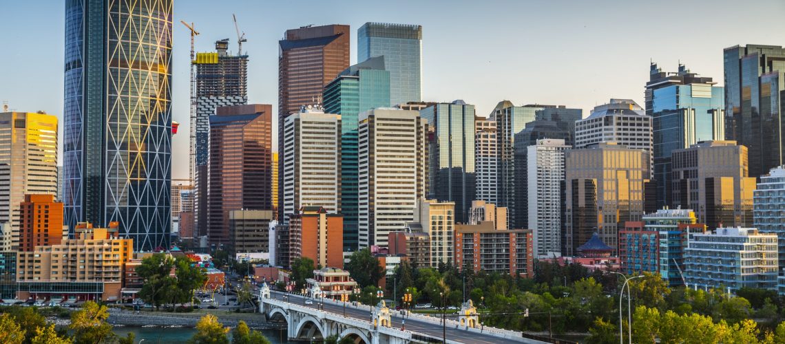 Calgarys skyline with its skyscrapers and office buildings. Bow river and centre Street Bridge in the foreground. Alberta - Canada