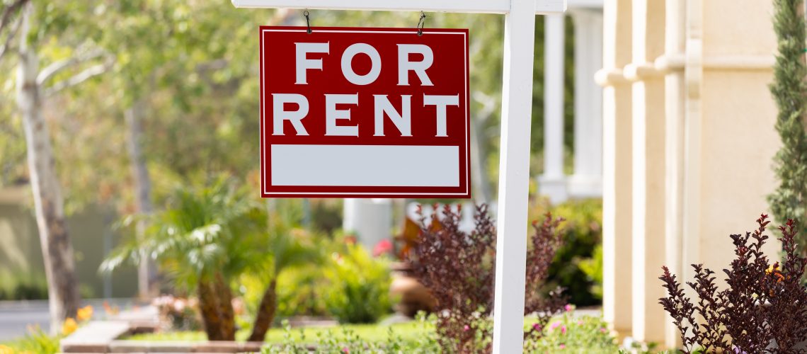 Red For Rent Real Estate Sign in Front House.